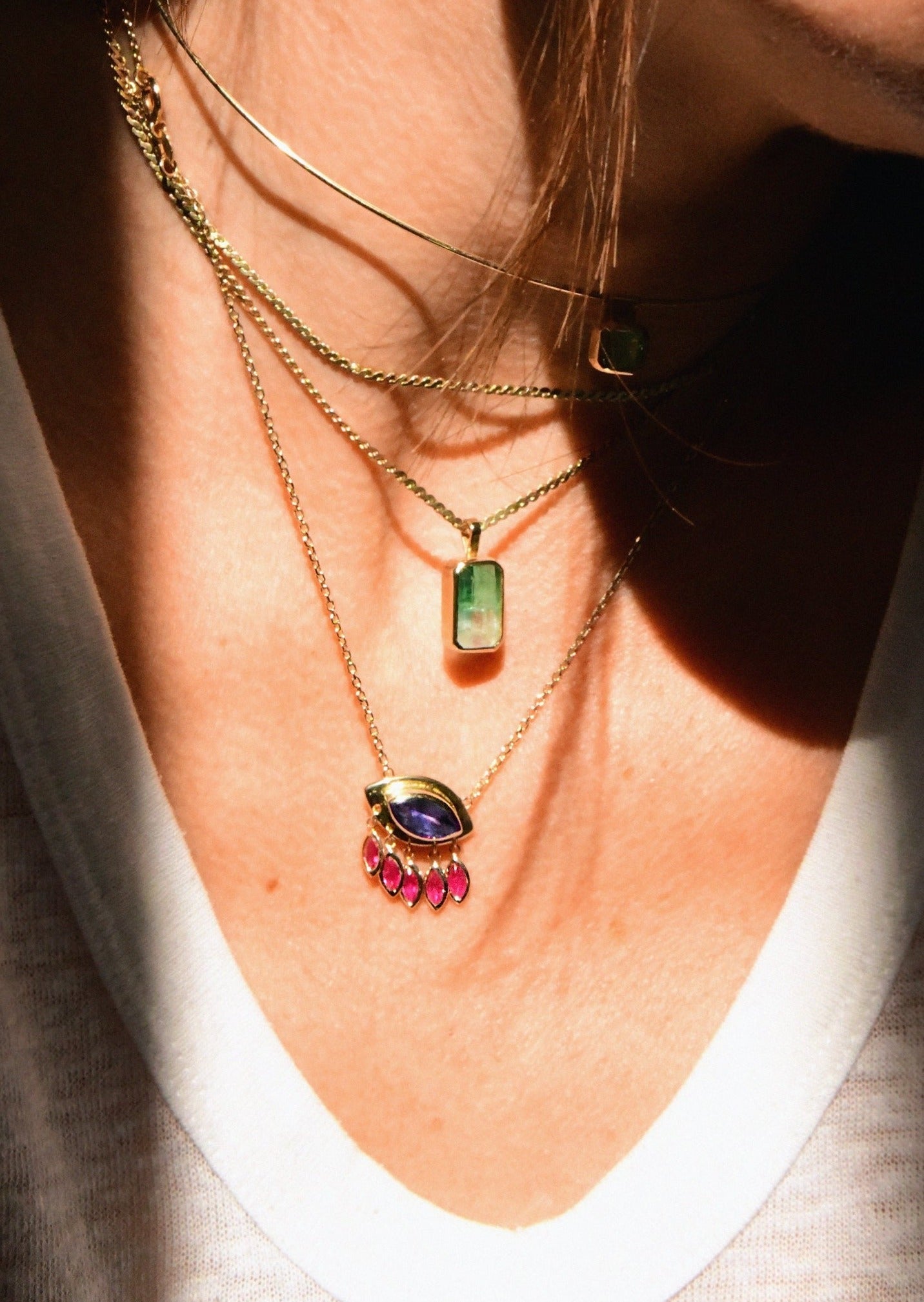 Protective evil eye charm necklace with blue tanzanite and vibrant ruby accents on cable chain