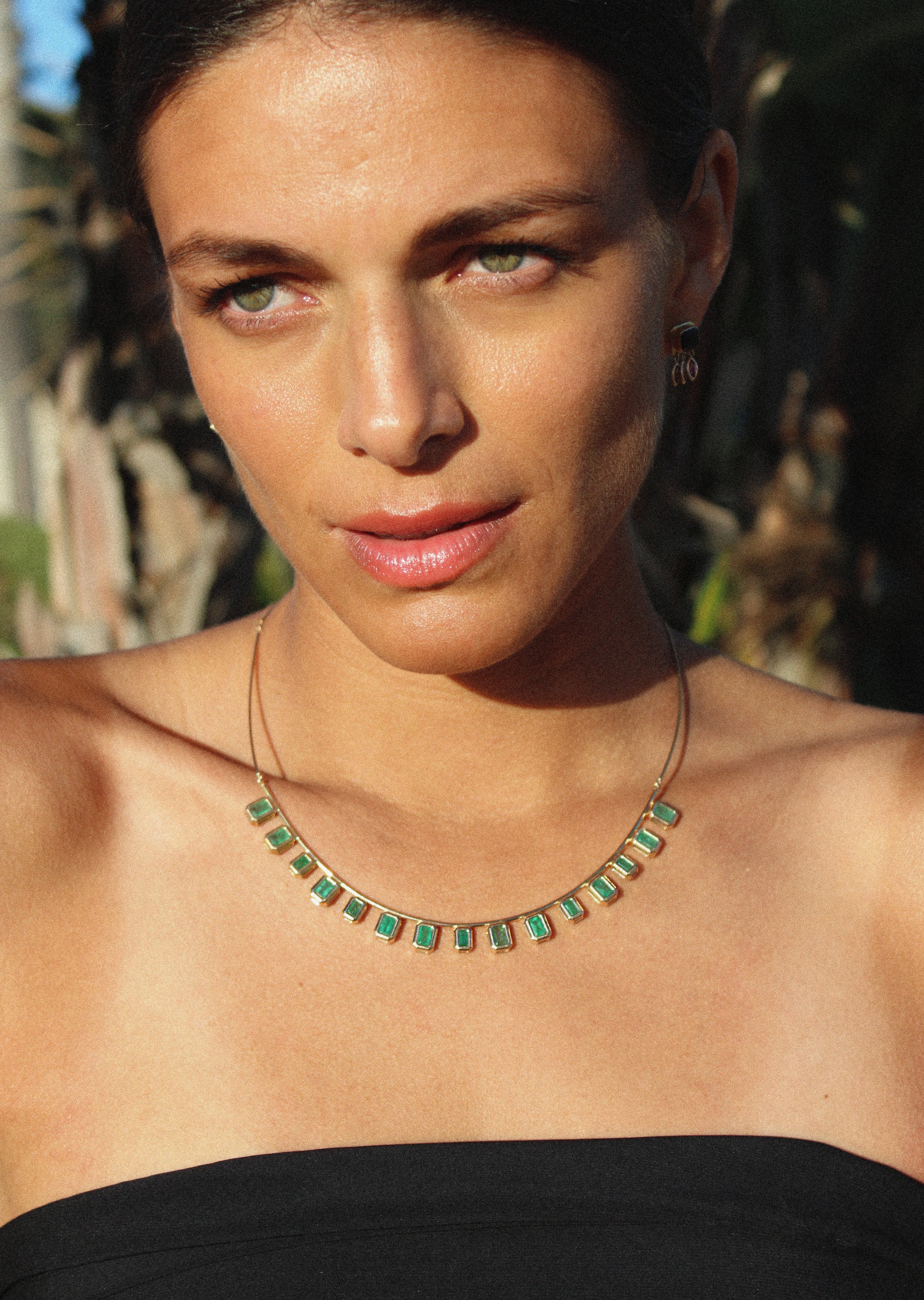 Minimalist gold statement necklace with vibrant emeralds a perfect as a stackable necklace.