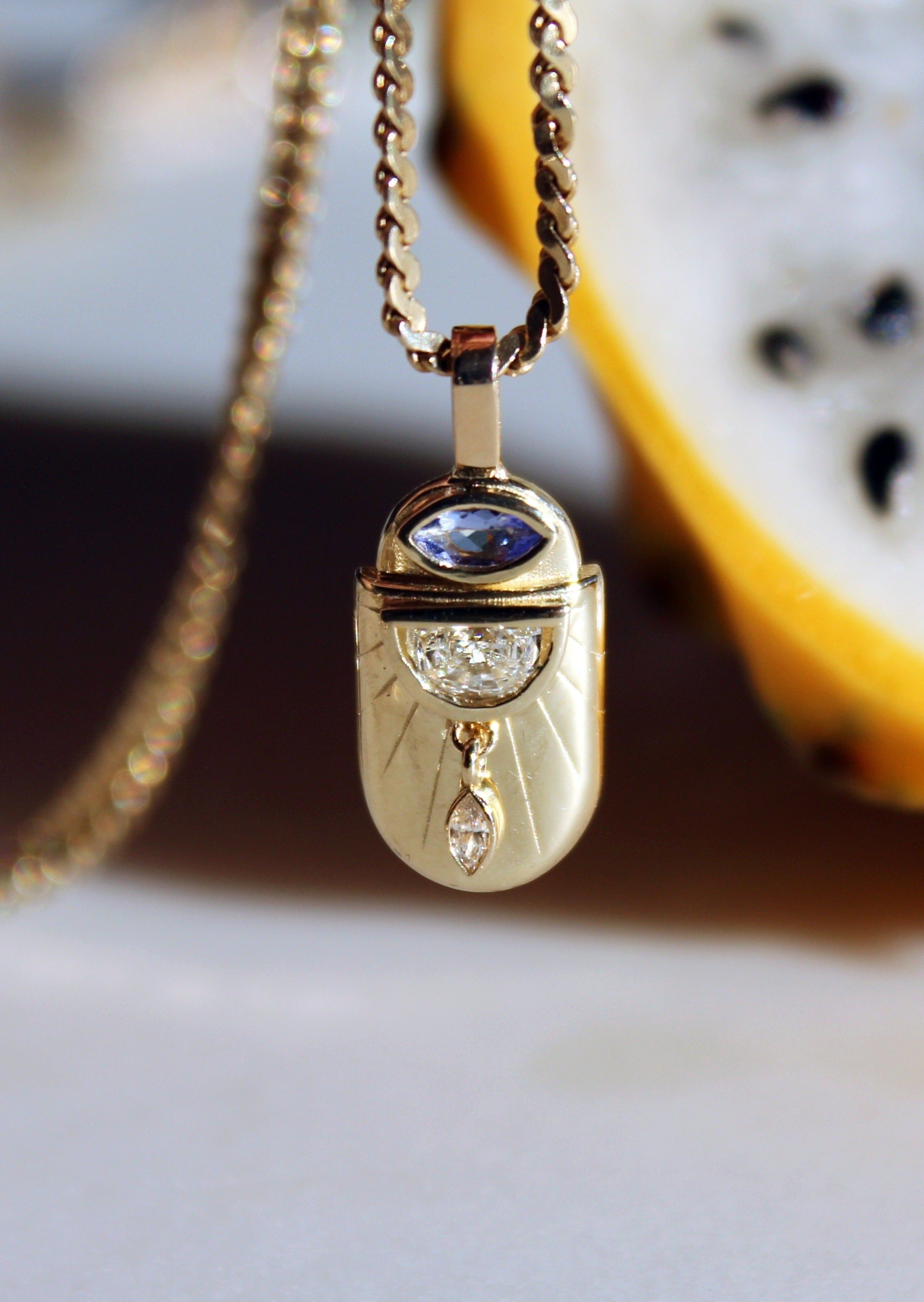 Talisman amulet necklace pendant with dangling diamond detail in celestial-inspired design