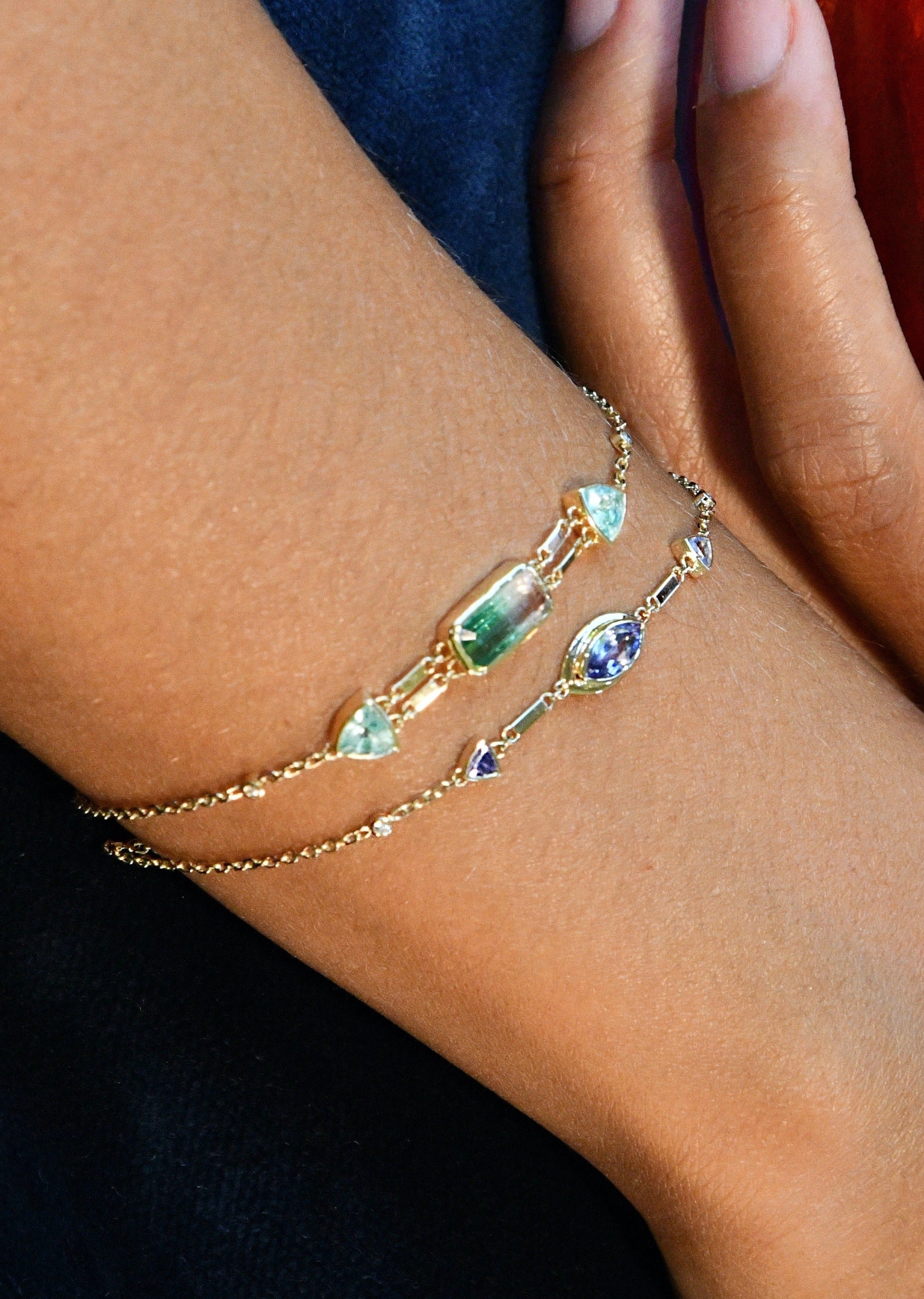 Gold chain bracelet featuring tanzanite stones and diamond details, designed for versatile wear as a dainty accessory