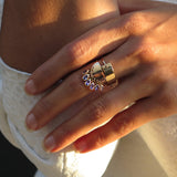 hand wearing golden parachute shaped ring