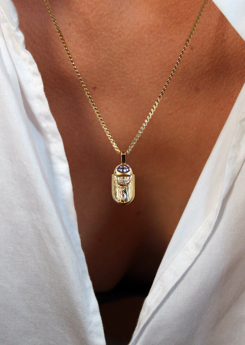 person wearing scarab shaped pendant with tanzanite 