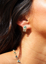 woman wearing triangle shaped emerald earrings with dangling diamonds